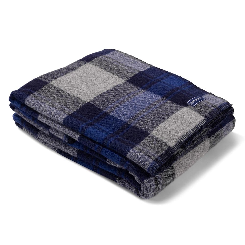 Faribault Mill North Shore blue middleweight wool bed blanket, folded and displayed at an angle to highlight the thickness, loft of the wool, and whipstitched edges.