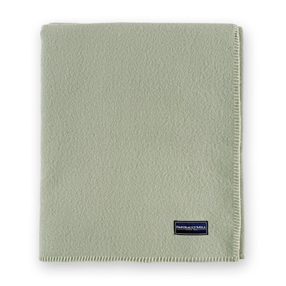 Faribault Mill Pure and Simple sea glass middleweight wool bed blanket, folded and displayed in a top-down view.