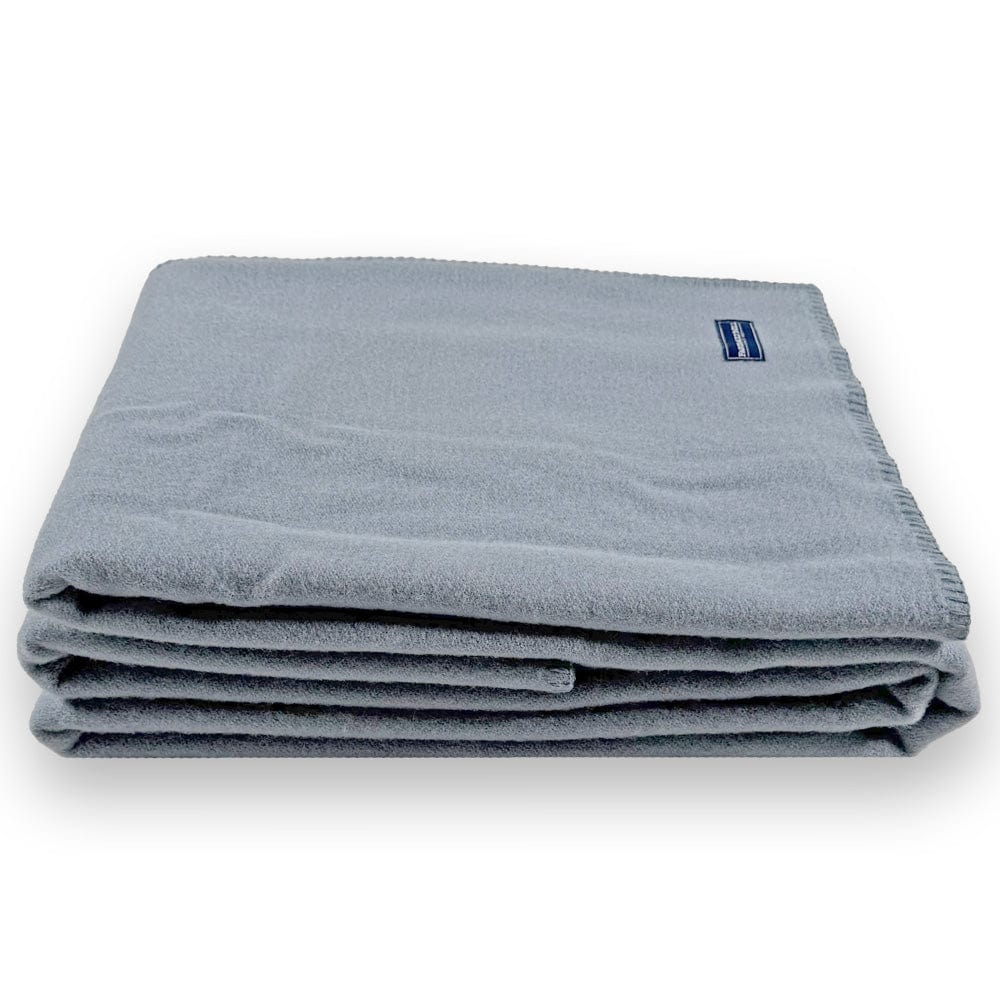 Faribault Mill Pure and Simple sky blue middleweight wool bed blanket, folded and displayed from the side to show the stacked layers and thickness.