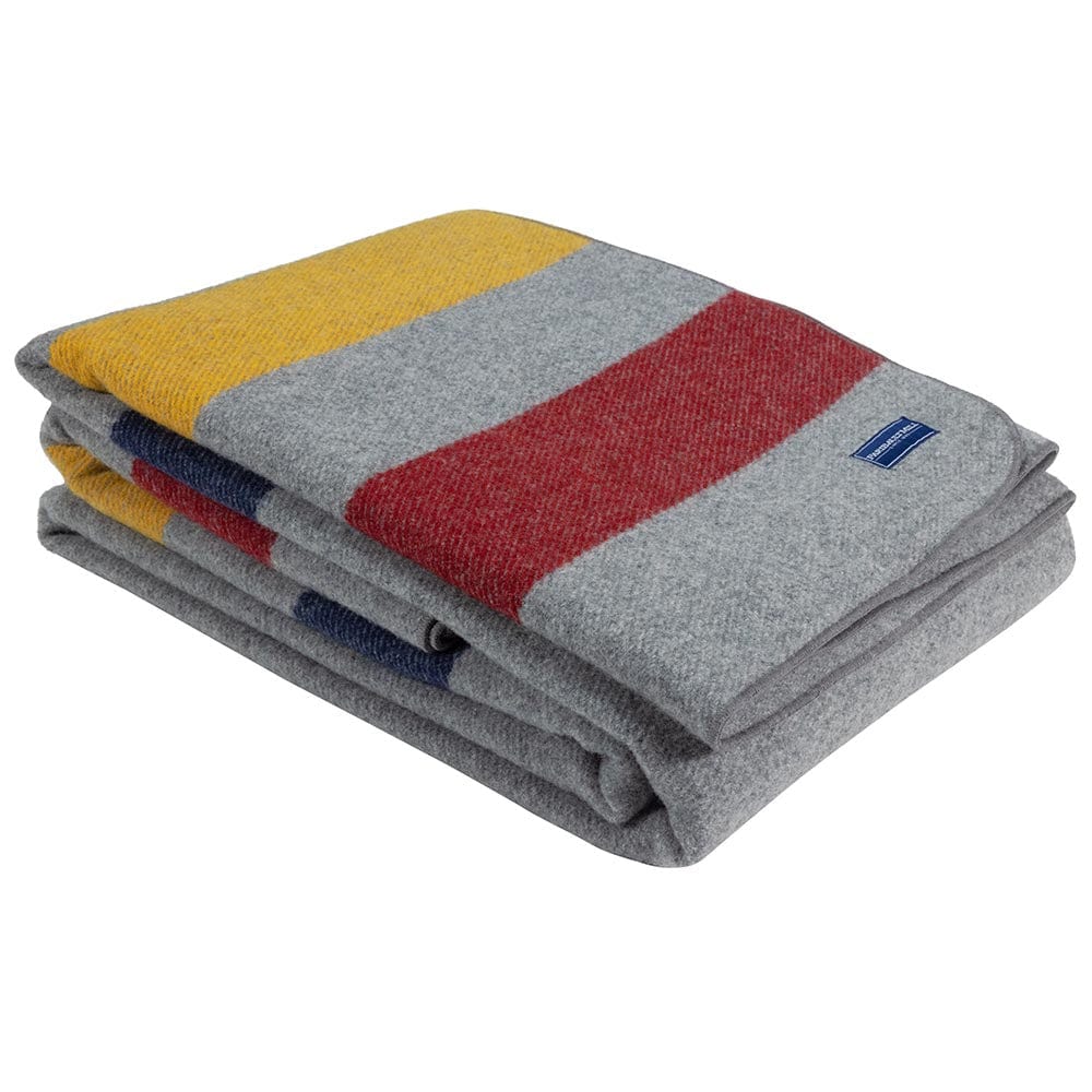 Faribault Mill Frontier gray heavyweight wool bed blanket, folded and displayed at an angle to highlight the thickness, loft of the wool, and serged edges.